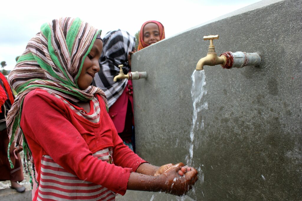 Nezifa Seid washing her hands under running water from the newly-built water point.