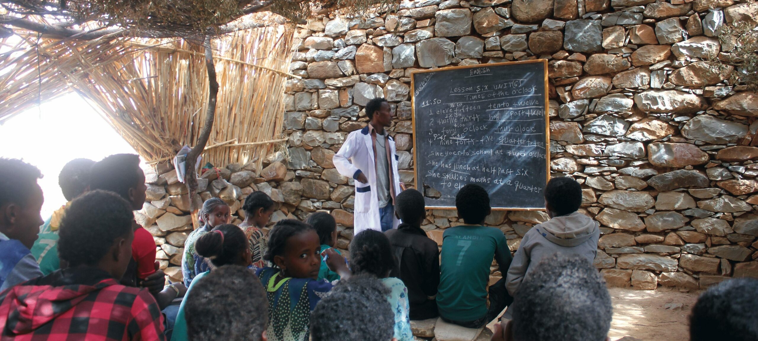 A teacher educating children in his open-air classroom.